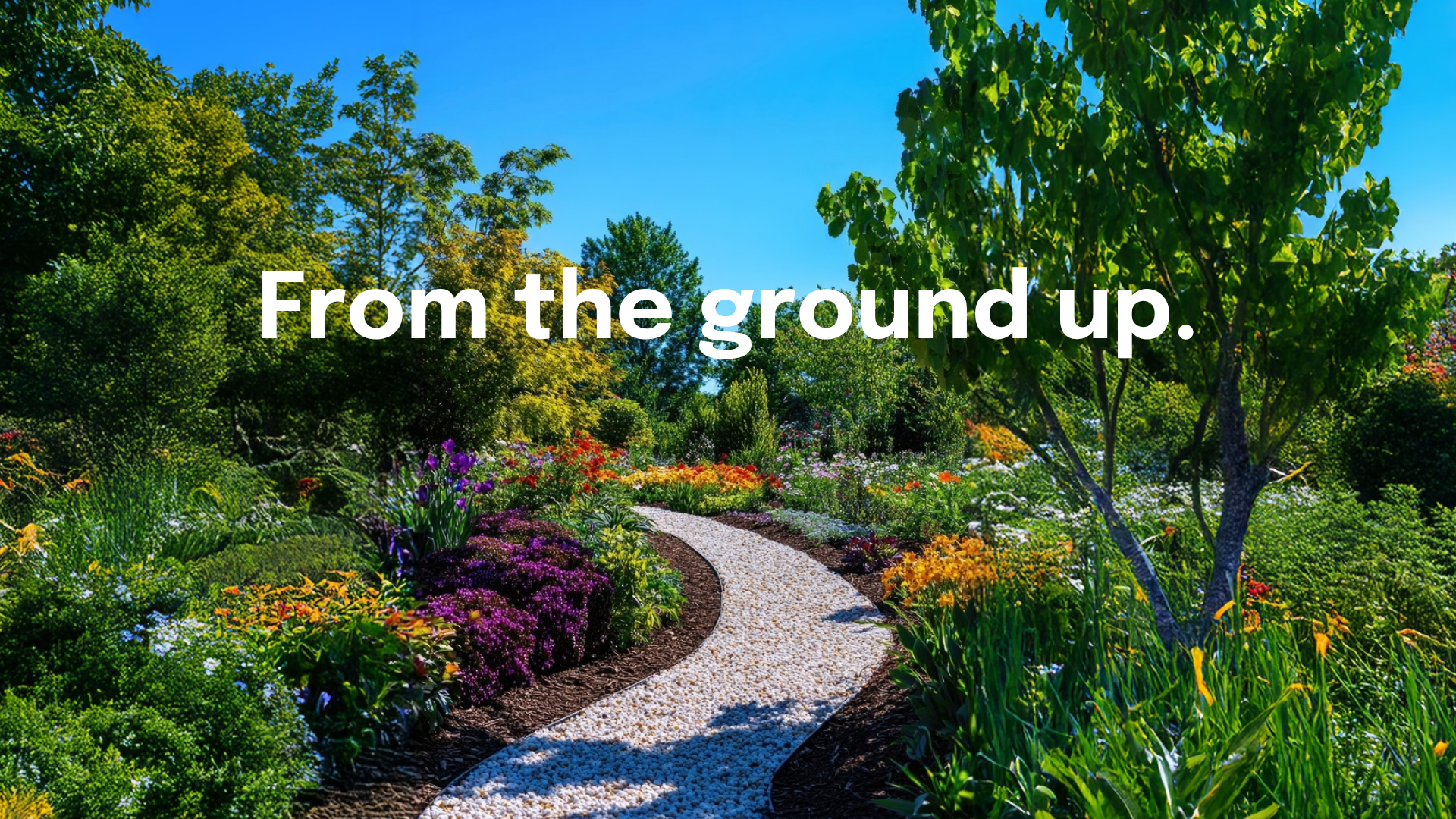 Curved gravel path through a landscaped garden bed with flowering plants and shrubs. Cannings Outdoor Power Equipment